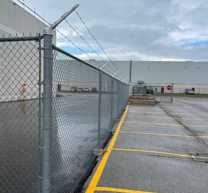 chain link security fence with barbed wire installed for commercial property