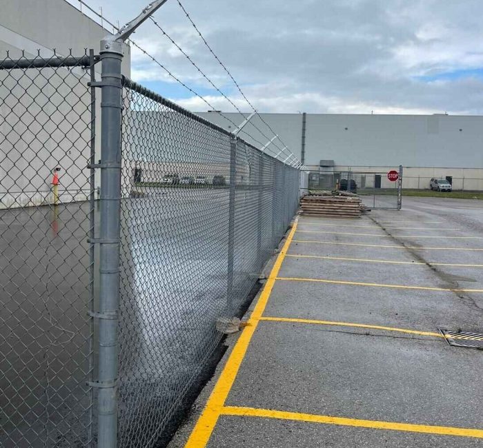 chain link security fence with barbed wire installed for commercial property